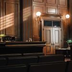 Empty courtroom interior with wooden judge's bench and double doors