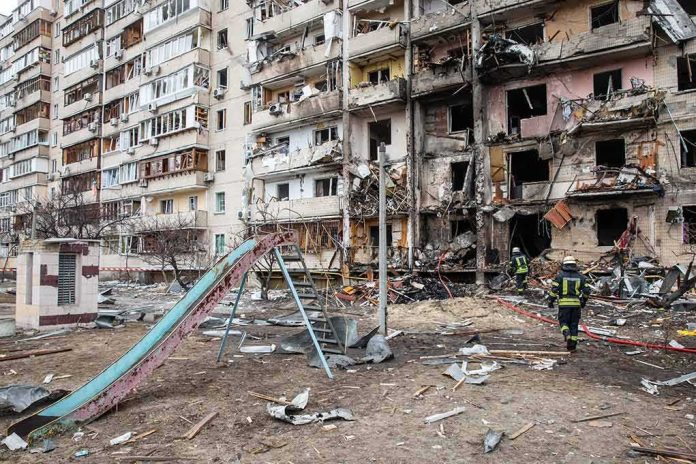 shutterstock_2129012939 Damaged apartment building behind a playground slide