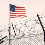 Five Nabbed Near US-Linked Base American flag above barbed wire fence