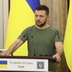 High-Stakes Shuttle Jolts Ukraine Talks Man at a podium with Ukrainian flags