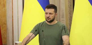 High-Stakes Shuttle Jolts Ukraine Talks Man at a podium with Ukrainian flags