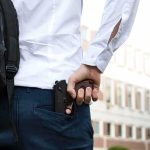 Sheriff Clears Dad – NAACP Demands Action person holding a handgun behind their back near a building