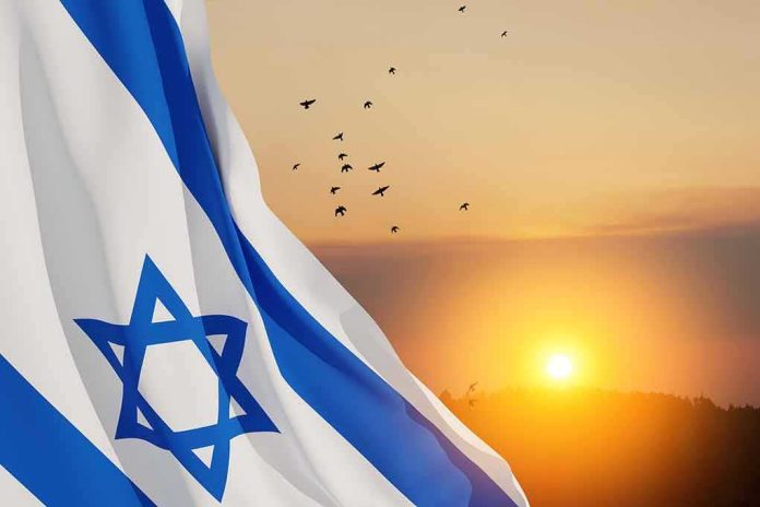 shutterstock_2246162359 Israeli flag waving at sunset with birds in the sky