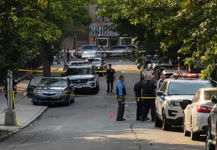 shutterstock_2330301305-3 Police officers secure a residential street with patrol cars and yellow tape