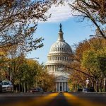 Military Complex Hides In Monument? United States Capitol dome framed by a tree-lined street