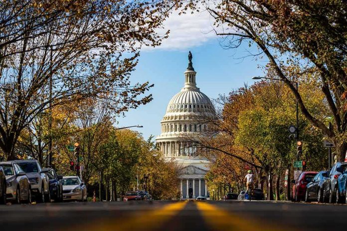 shutterstock_2572235099-1 United States Capitol dome framed by a tree-lined street
