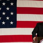 Trump’s Stark 9/11 Message Lands Hard Donald Trump at a podium with a large American flag backdrop