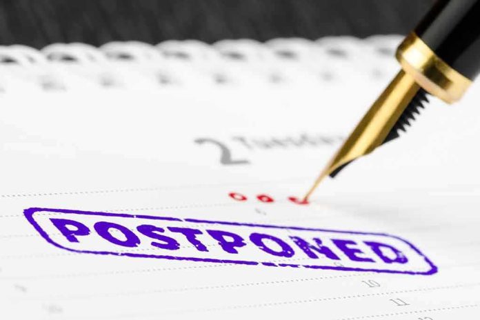 shutterstock_416765500 Fountain pen over calendar with postponed stamp