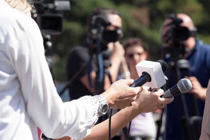 Reporters hold microphones during an outdoor press interview