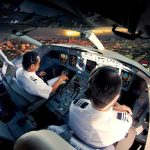America’s Hero Confronts A Silent Killer Pilots in an airplane cockpit during city approach at sunset