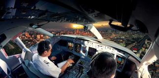 America’s Hero Confronts A Silent Killer Pilots in an airplane cockpit during city approach at sunset
