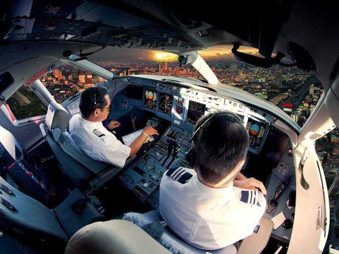 shutterstock_512612131 Pilots in an airplane cockpit during city approach at sunset