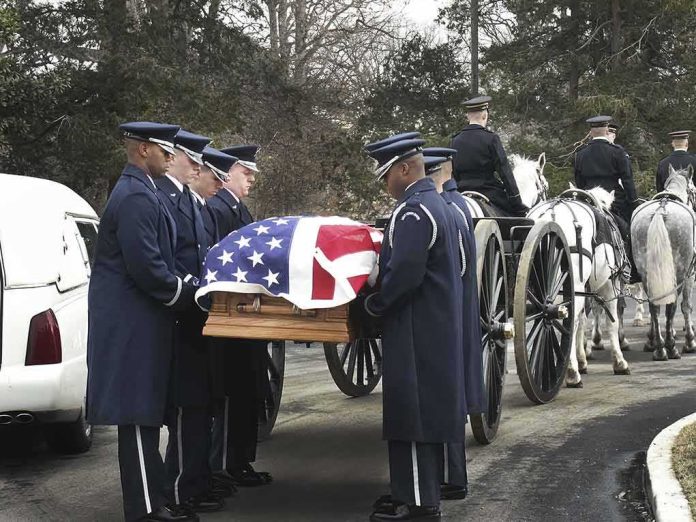 shutterstock_517705045 Military honor guard carries a flag-draped casket beside a hearse and caisson
