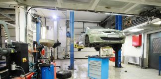 Car on hydraulic lift in auto repair shop