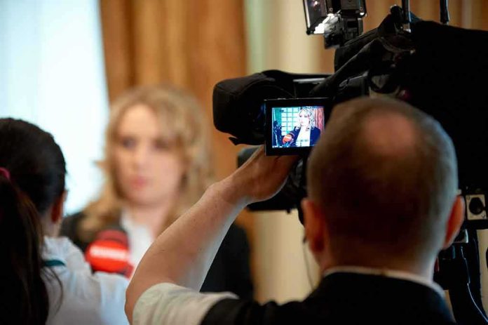 shutterstock_607357001 tv camera films interview with blurred speaker