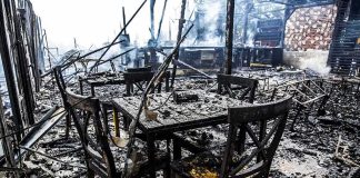 Burned dining tables and chairs in a fire-damaged building