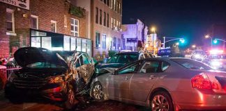 two cars collide on a city street at night