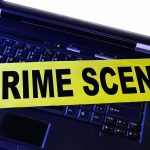 Laptop keyboard with yellow crime scene tape across it