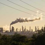 War Hits Moscow’s Front Yard Industrial refinery with smokestack emitting plume at sunset