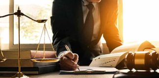 NFL Star’s Dark Trial Twist Lawyer writing at desk with scales and gavel