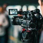 Video camera filming a group of people