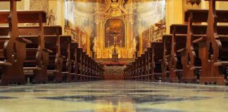 Church Pays $800 Million – What Are They Hiding? Church interior with wooden pews facing ornate altar