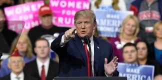 Audi’s $4B Bombshell At Trump Rally Donald Trump speaking at a rally podium, pointing toward the audience