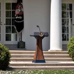 Trump Drops Bombshell on Press Chief Podium with presidential seal in a garden colonnade