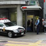 Japanese police box with patrol car and officers speaking to two men