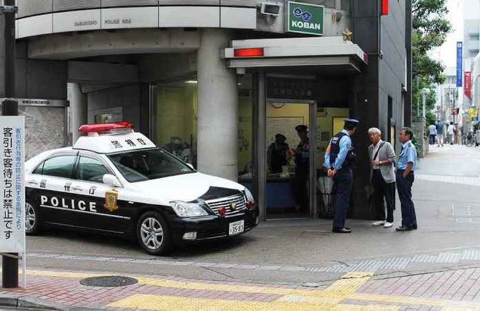 Japanese police box with patrol car and officers speaking to two men