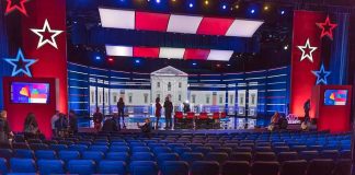 Tight Race, Candidate Disappears Debate stage with red and blue lighting and empty audience seats