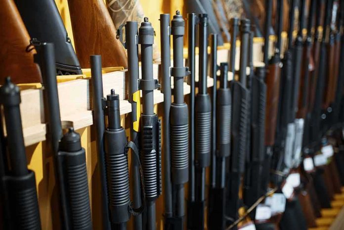 Shotguns and rifles lined up on a rack in a gun store