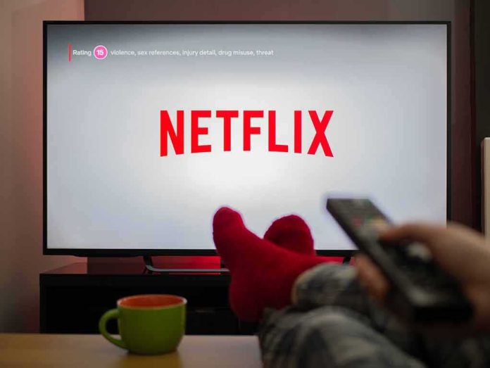 TV screen displaying Netflix with person holding remote