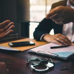 FBI Storms OpenAI Boardroom Two people in discussion at a desk with handcuffs and documents