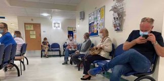 America’s Heart Care Bottleneck People wearing masks seated in a hospital waiting room