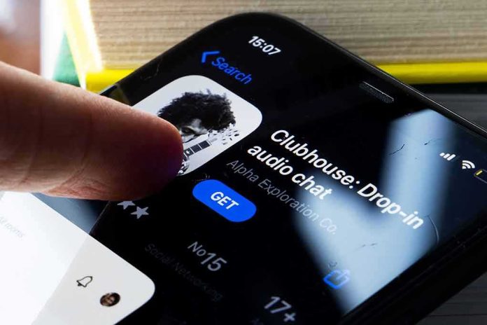 shutterstock_1903690942 Smartphone screen showing Clubhouse app page with a finger about to tap Get