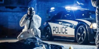Church Funeral Massacre Stuns Mourners forensic investigator photographing crime scene near police car