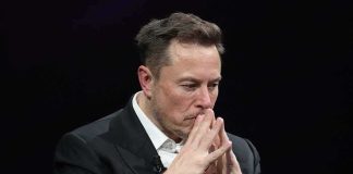 Elon Musk seated with hands steepled in thought