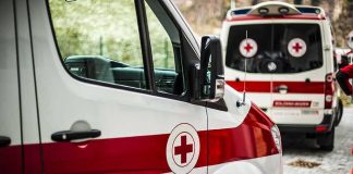 Ambulances with red cross markings parked on a cobblestone street