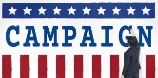 Flu Claim Or Psychiatric Stay? Man in suit writing on large campaign banner with stars and stripes