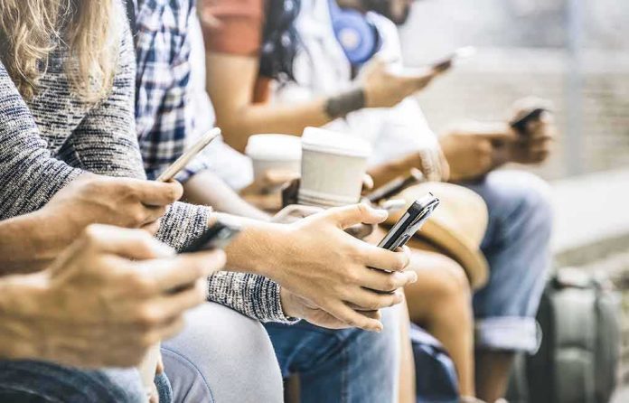 Group of people sitting and using smartphones